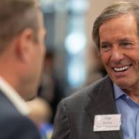 Dan Devos in conversation with and smiling at other event guest